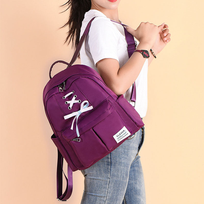 Mochila de nailon para mujer con detalle de lazo: compacta, con varios bolsillos y correas de hombro ajustables