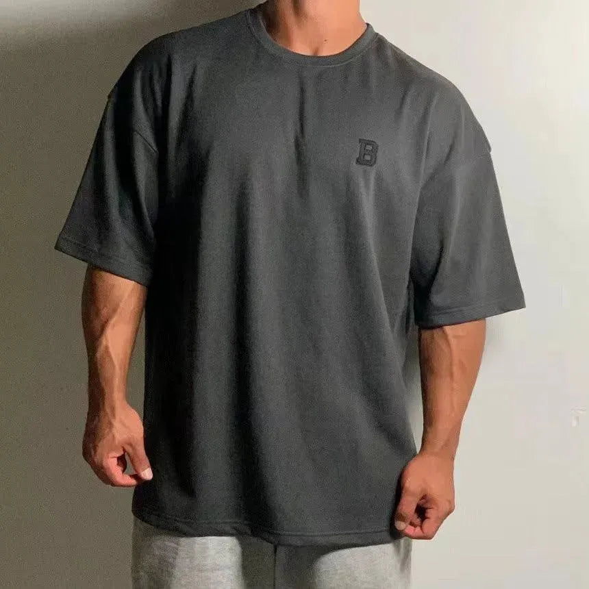 Pánské oversized fitness tričko – volný tréninkový top s kulatým výstřihem a spadlými rameny