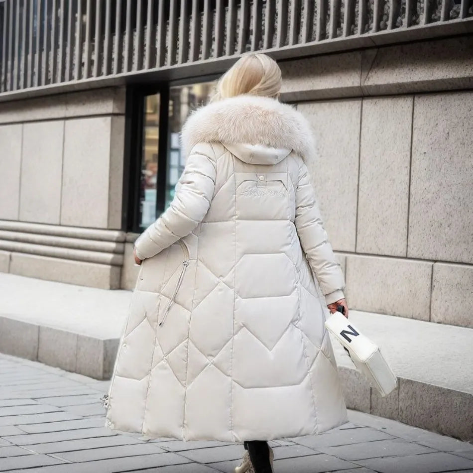 Női hosszított, steppelt pufi télikabát oversized, szőrmével szegélyezett kapucnival és állítható derékkal – meleg, bélelt maxikabát elegáns, lezser hideg időjárási összeállításokhoz és mindennapi téli rétegezéshez