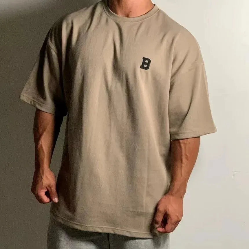 Pánské oversized fitness tričko – volný tréninkový top s kulatým výstřihem a spadlými rameny