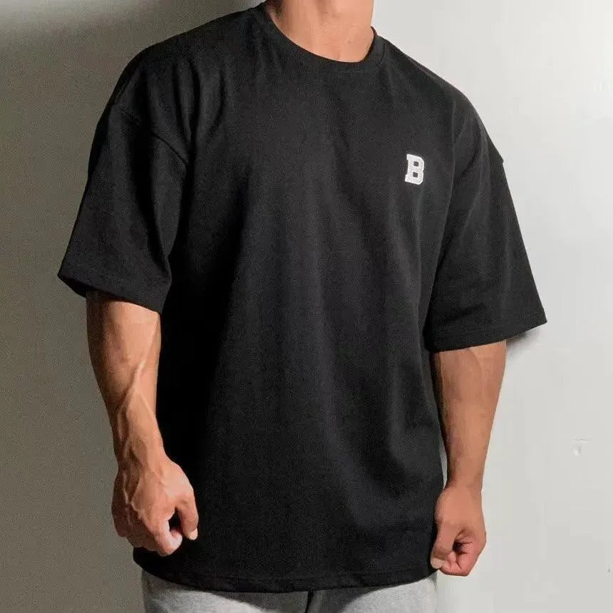 Pánské oversized fitness tričko – volný tréninkový top s kulatým výstřihem a spadlými rameny